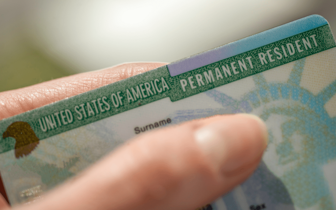 A person holding their green card in his hand.